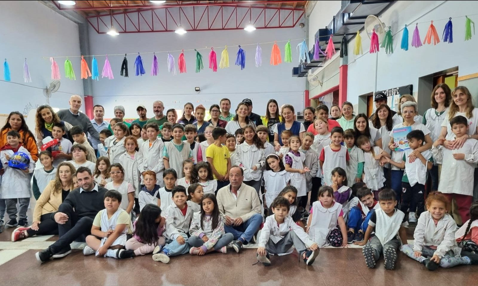 Docentes y alumnos posan en una escuela junto con el representante de seguridad provincial, luego de participar en actividades de educación y prevención en materia de seguridad vial.