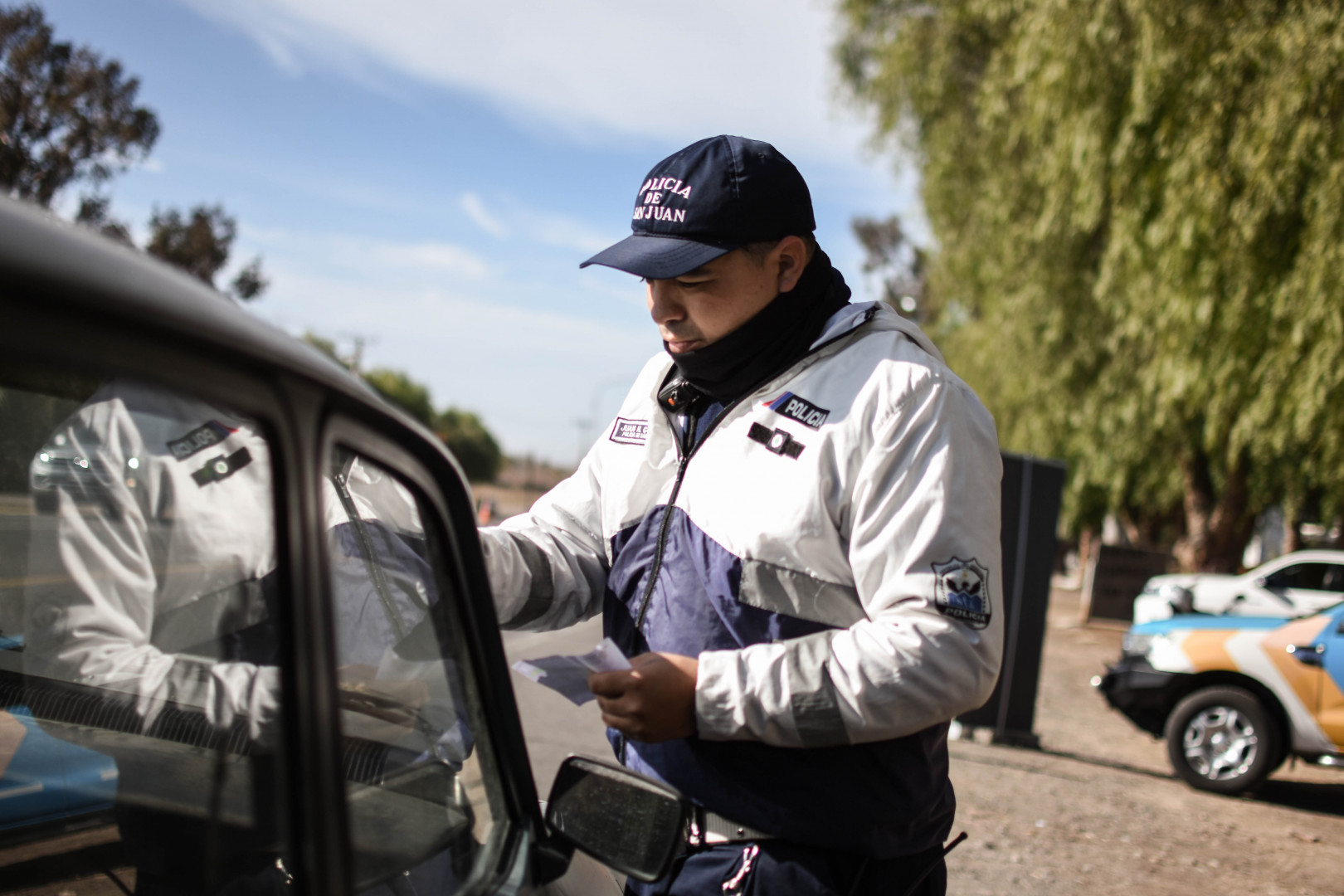 Imágen que retrata a un agente de policia de San Juan solicitando documentación a un automovilista, en el marco de la jornada de control conjunta entre la Secretaría de Tránsito y Transporte Provincial, la Agencia Nacional de Seguridad Vial y la policía de San Juan.