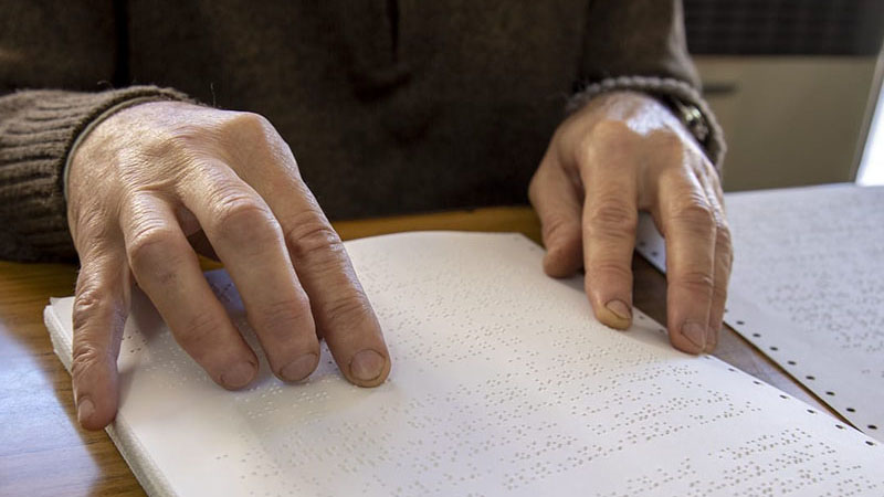 Manos de una persona que está leyendo braille.