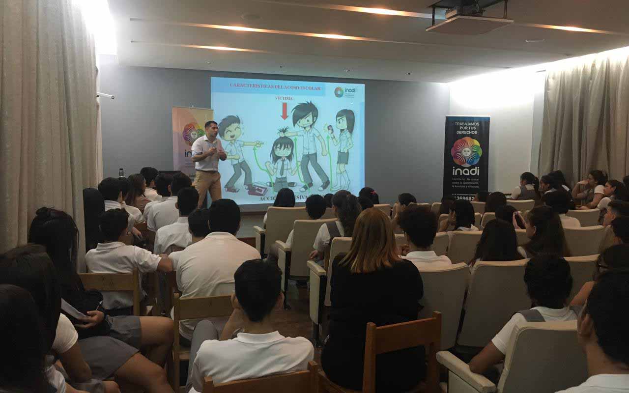 Persona dando un taller ante un grupo de estudiantes sentados en un microcine