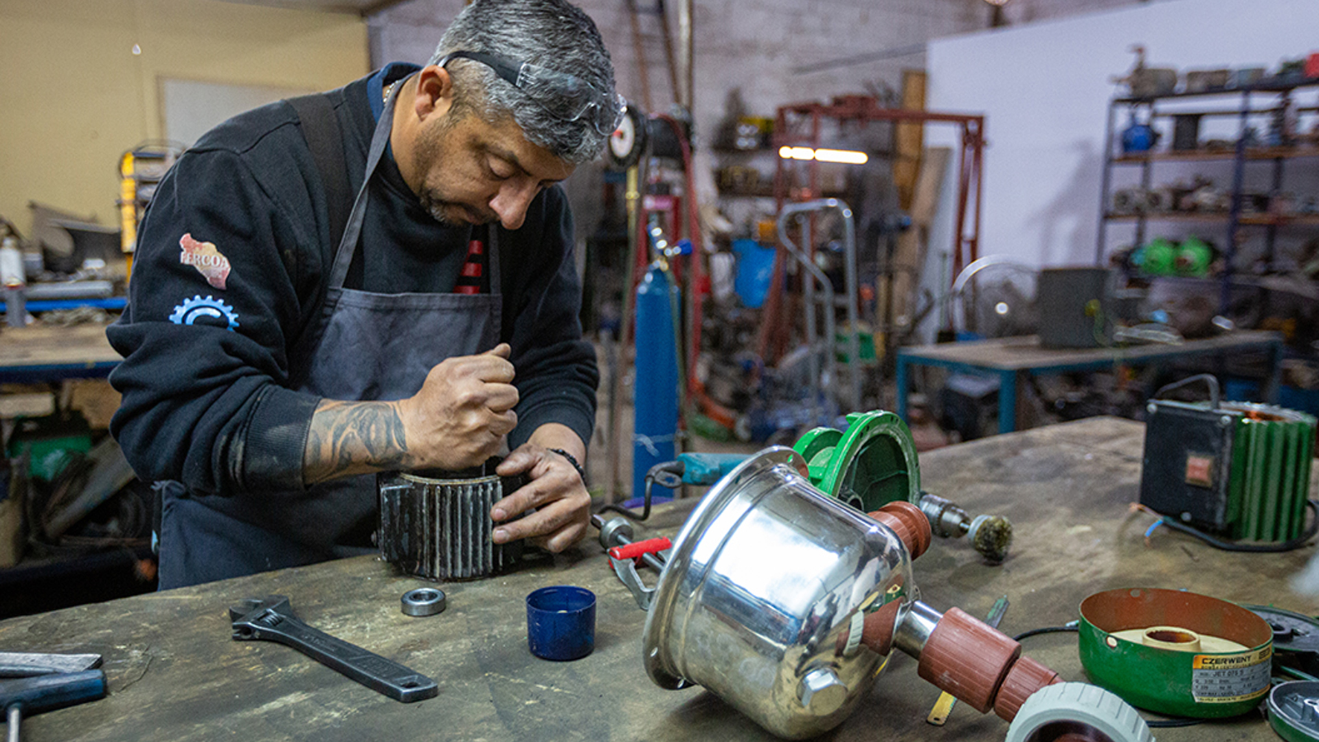 Hombre trabajador de la cooperativa Selius reparando motor de cisterna.