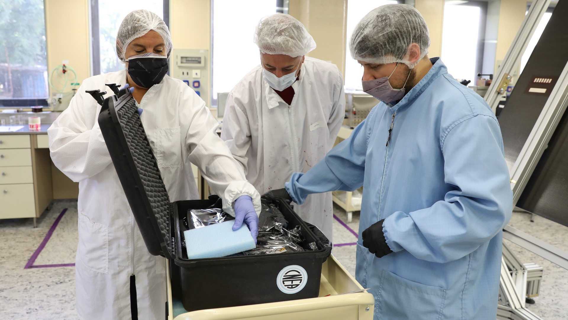 El doctor Hernán Socolovsky junto al equipo del DES preparando el embalaje de detectores satelitales en el área limpia del Centro Atómico Constituyentes (CNEA).