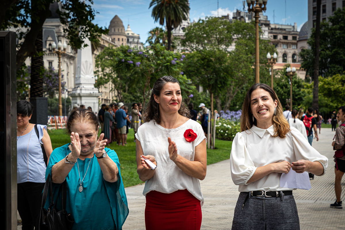 Tres personas aplauden en la Plaza de Mayo