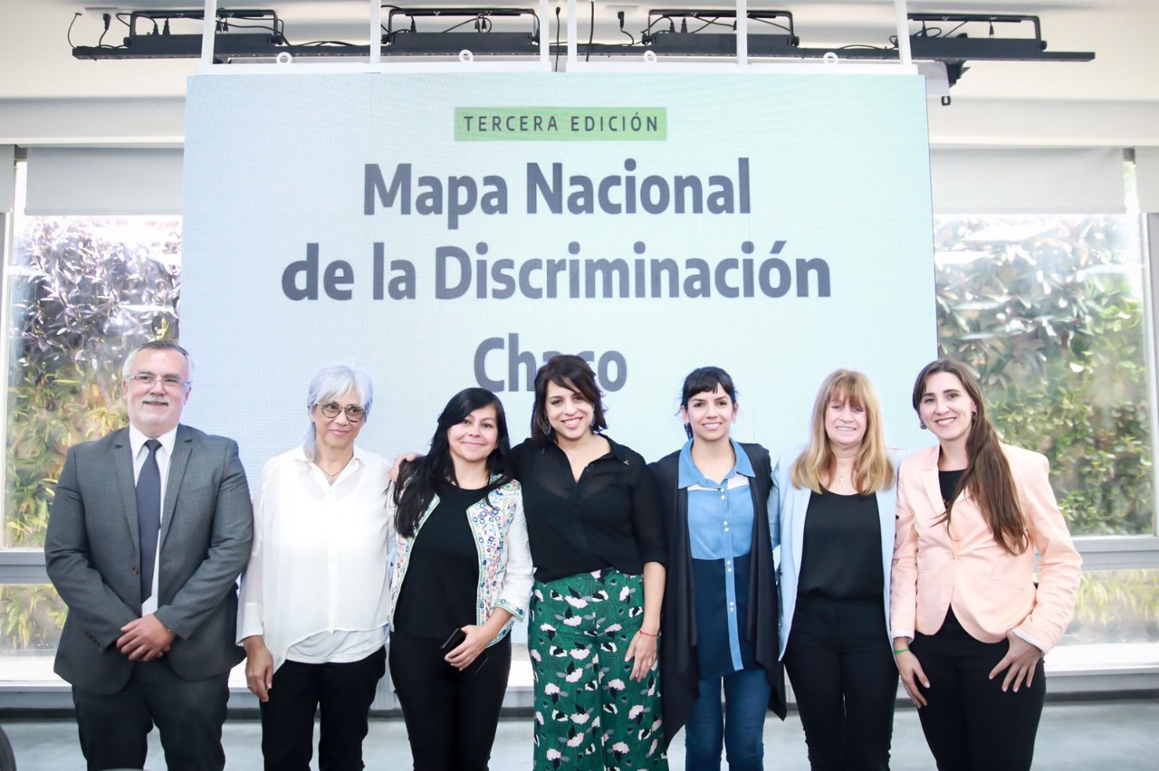 Funcionarios y panelistas posan al final de la presentación con la filmina de fondo con la leyenda "Mapa Nacional de la Discriminación"