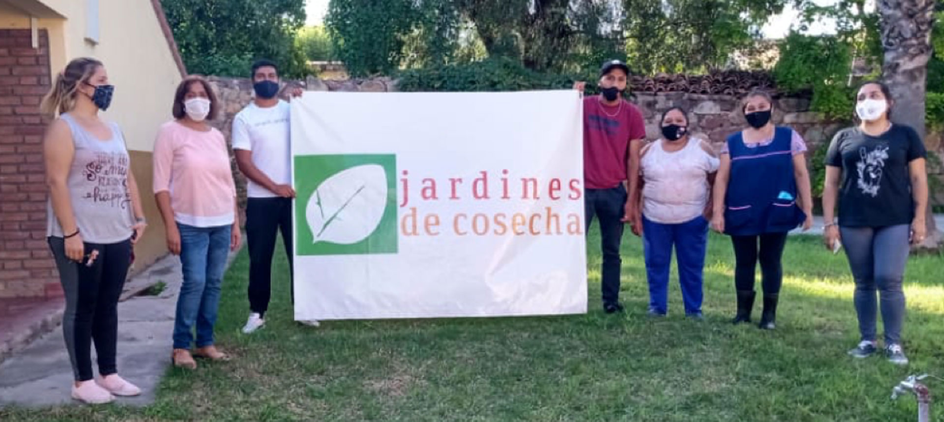 Foto de integrantes del jardín sosteniendo un cartel con el logo del jardín