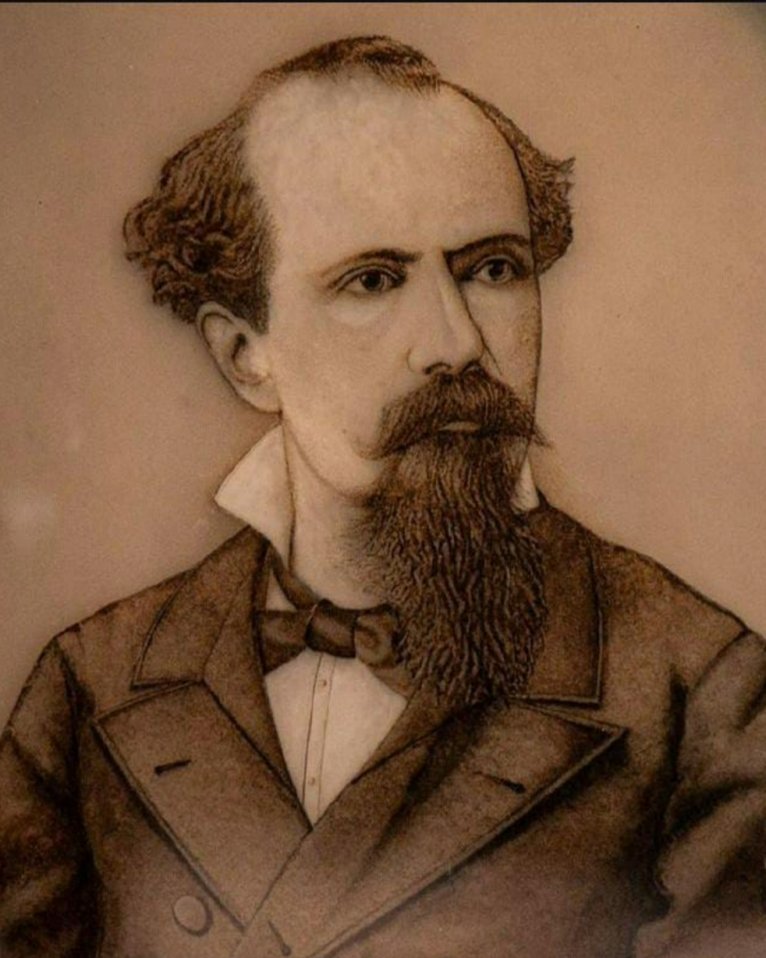 Retrato de Nicolás Avellaneda (1895). La imagen muestra un retrato antiguo de un hombre con barba y bigote. Tiene el cabello oscuro y rizado en los lados, pero calvo en la parte superior de la cabeza. Viste un traje formal con una camisa blanca y una pajarita. Su expresión es seria y está mirando hacia un lado.