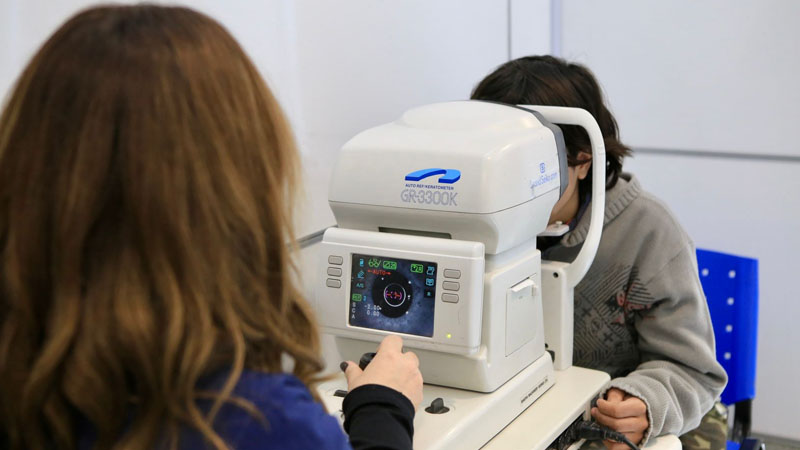 Un profesional de la salud se encuentra usando una máquina especializada para el control ocular.