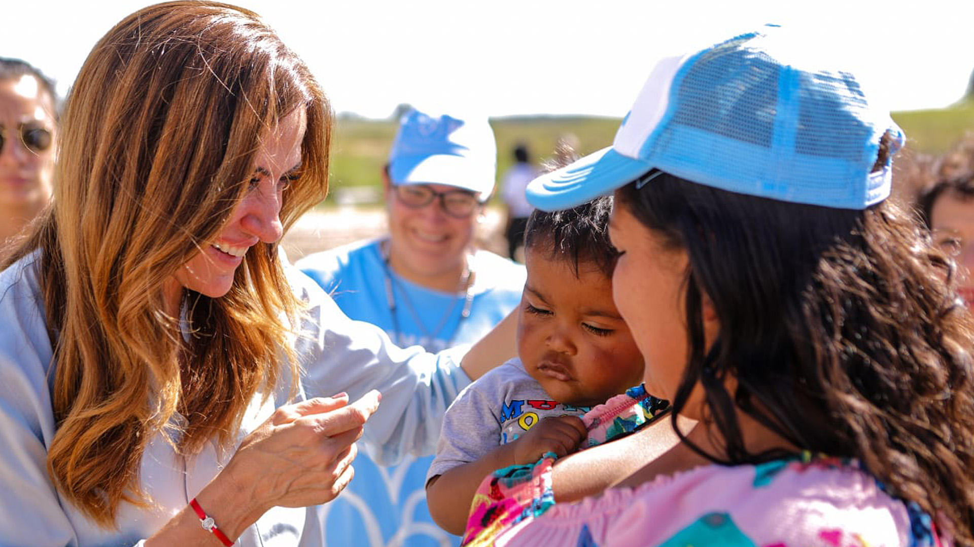 La ministra junto a una mujer y su pequeño hijo en las obras donde se realizará el programa Lote con Servicios de la SISU.