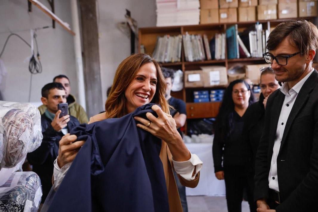 La ministra sonriendo y tocando una de las prendas que confecciona la cooperativa Textil Blanco País de Morón.