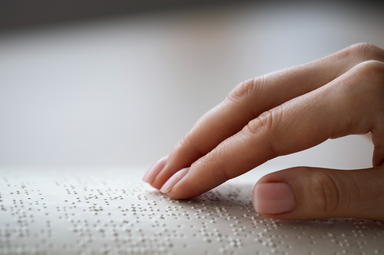Fotografía donde se observa la mano de una persona leyendo una partitura en Braille.
