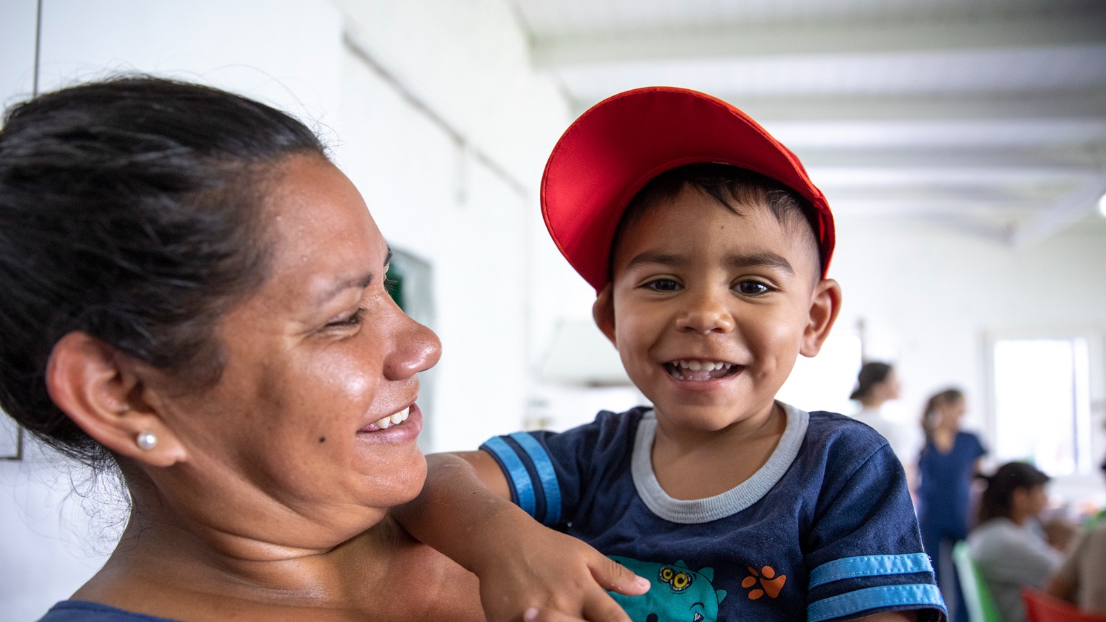 Madre mirando a su hijo en brazos.